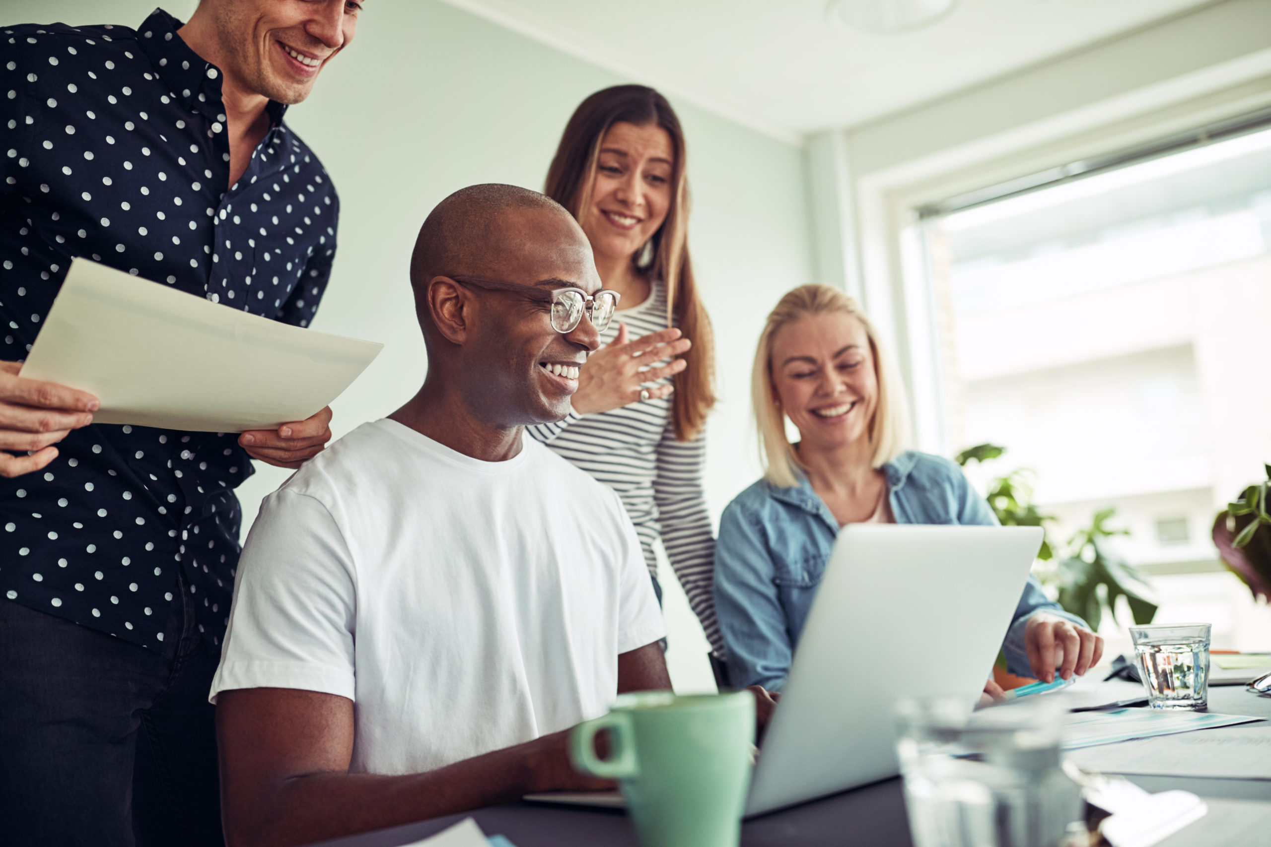 Diverse businesspeople smiling while working online together in